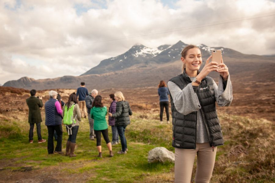 People hiking and taking photos of mountains.