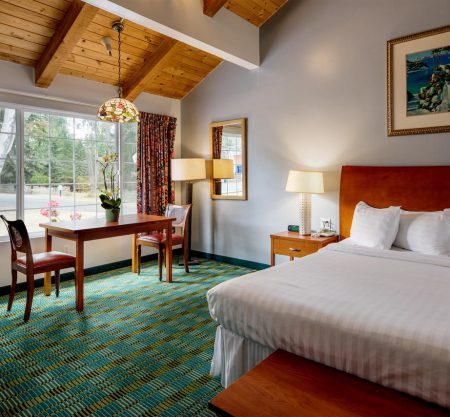 Cozy hotel room with king bed and table.