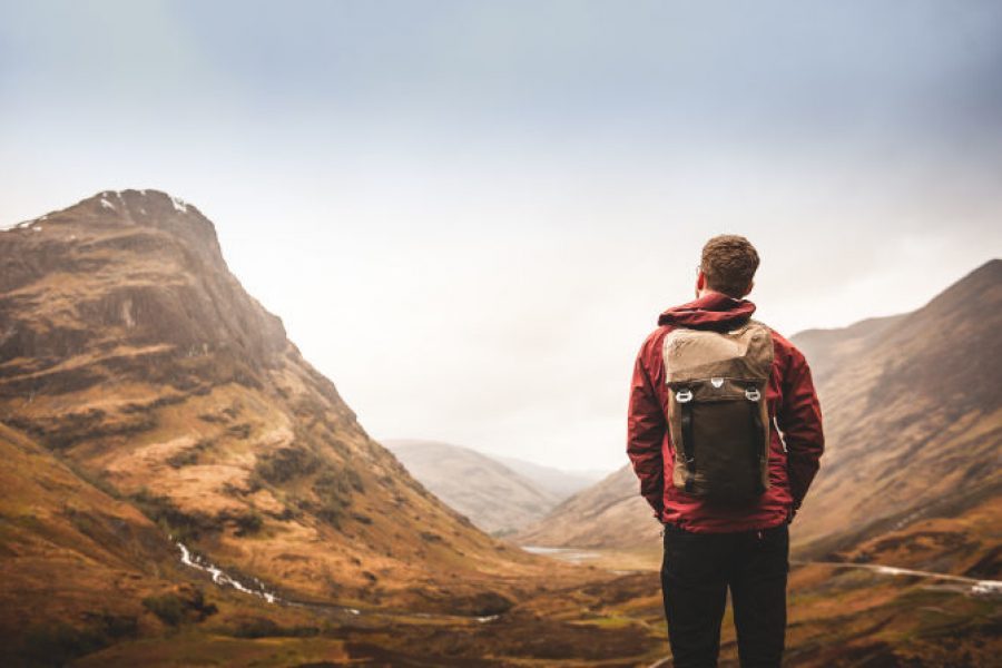 Hiker admires scenic mountain landscape view.