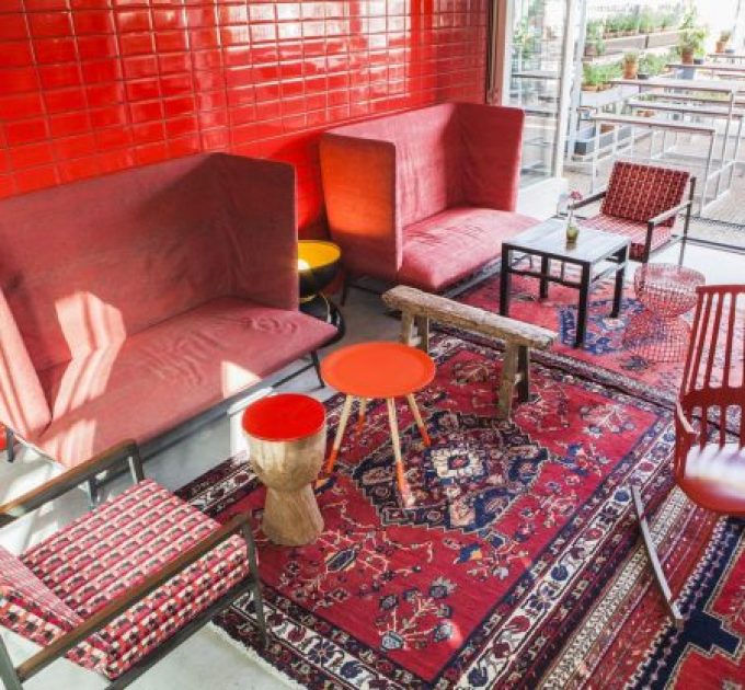 Colorful lounge area with red furniture and rugs.