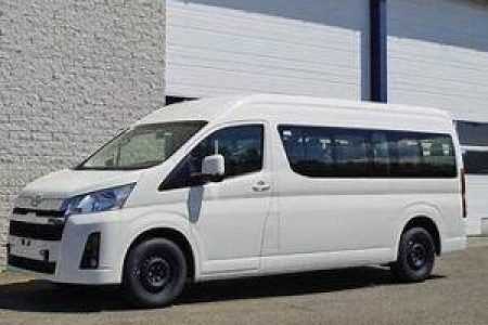 White passenger van parked by industrial building