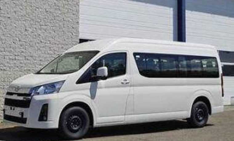 White passenger van parked by industrial building